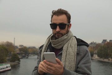 Fototapeta premium Modern guy using cellphone in the European city.