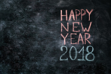 Happy 2018 new year card template with white chalk greetings on blackboard.