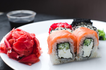 on the plate is white, lined with different rolls, sushi