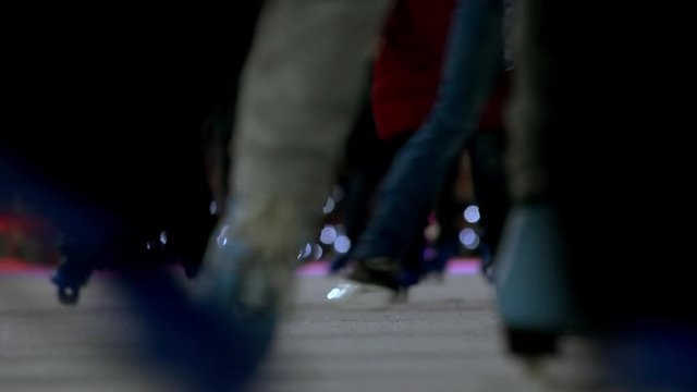Close view of skating feet. Blue and black skates.