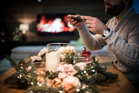 Bearded man photographing decorated christmas table