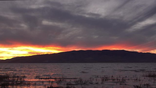 Sunset slowly fades away over Utah Lake as the clouds turn dark and the horizon glows.