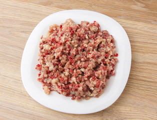 Raw ground meat on a white plate. Minced meat from pork and chicken on a plate.
