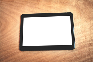 Digital tablet on a wood background.