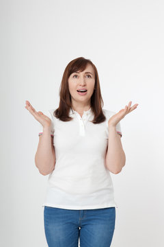 Portrait of surprised happy woman in blank white t-shirt with copy space on white background. Mock up