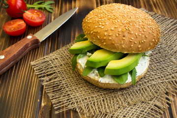 Vegetarian sandwich with avocado and arugula on the wooden rustic  background