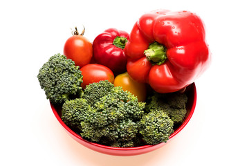 Broccoli, red and yellow tomatoes and bell peppers on plate