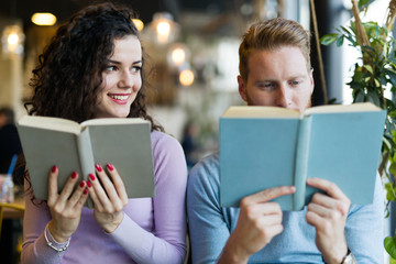 Young couple reading books in coffee shop