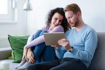 Young couple using digital tablet at home