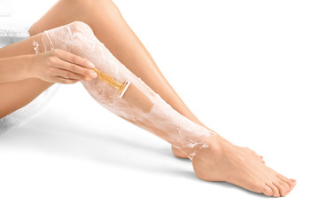 Obraz na płótnie Canvas Beautiful woman shaving her legs, isolated on white