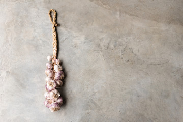 High angle view of plaited garlics on concrete background