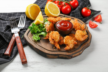 Board with tasty shrimp basket on wooden table