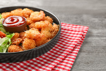 Plate with tasty shrimp basket and sauce on table