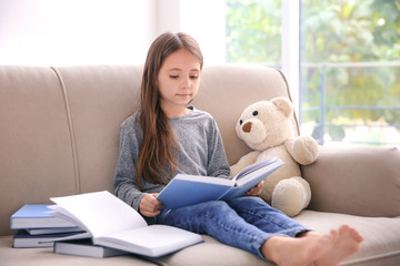 Cute little girl reading at home