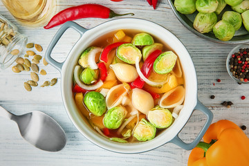 Vegan soup with Brussels sprouts in bowl on wooden table