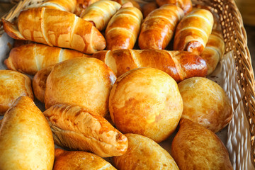 Fresh tasty bakery products in wicker basket