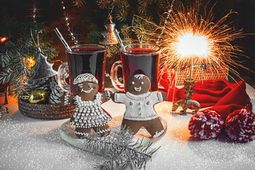 Christmas gingerbread and two glasses of mulled wine for the Christmas table on a background of garlands and Christmas twigs .