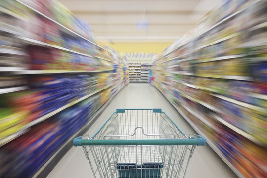 Supermarket aisle with empty shopping cart, Supermarket store abstract blurred background with shopping cart