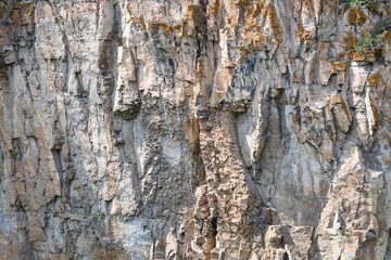 Fototapeta premium Detail closeup of a mountain rock wall, background or wallpaper of natural stone texture