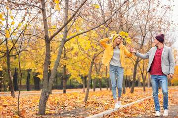 Young couple walking in park on autumn day