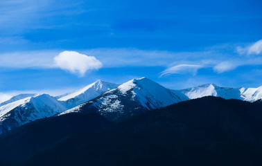 Naklejka na ściany i meble Mountain snow peak, beautiful natural winter backdrop. Ice top of the hill, blue sky background. Alpine landscape.