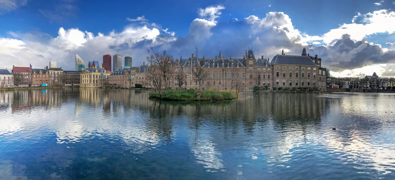 Panorama of the Dutch parliament building reflection on the pond under a freezing bright midday