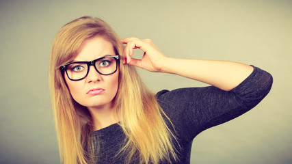 Nerdy woman in eyeglasses being confused