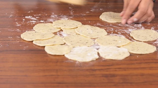 Indian Woman Rolling Out Well Shaped Poori using a wooden Rolling Pin - Closeup Shot 