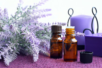 Bottles of essential oil, soap and candle with lavender