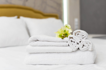 Fototapeta na wymiar Stack of towels with flower decor in a hotel room