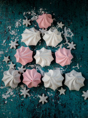 Homemade sweet white and pink meringue from egg white. Dark background.