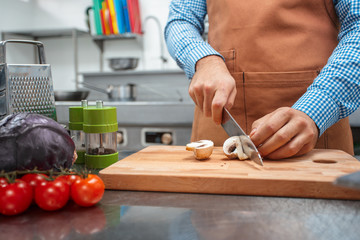 The chef in brown apron cooking in a restaurant kitchen