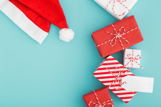 Gift Boxes Flat Lay And Santa Hat On A Blue Background.