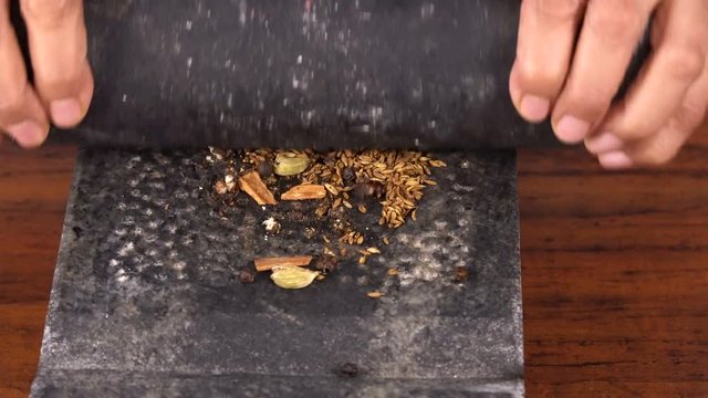 Roasted Indian Spices Grinding in the Stone Grinder - Closeup Shot 