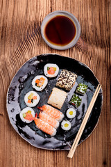 Sushi set on pottery plate with chopsticks and soy sauce in bowl