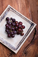 Black grapes on handmade square pottery plate