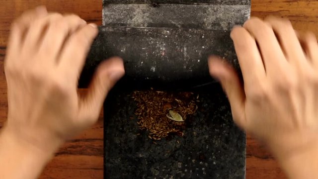 Top Angle Shot of Roasted Spices Grinding in the Stone Grinder, Indian Traditional Cooking