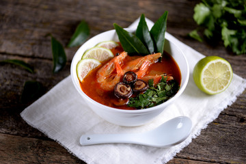 Thai soup Tom Yam with mushrooms, shrimps, lime and cilantro.