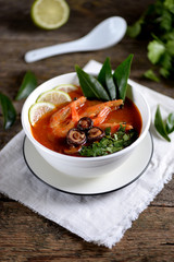 Thai soup Tom Yam with mushrooms, shrimps, lime and cilantro.