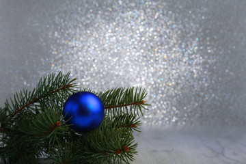 Decorative background with fir branches and blue balls on the silver. Christmas card Holiday Concept