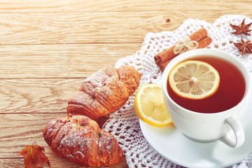 white cup of tea with cookies on a wooden background