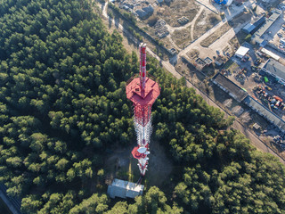 Aerial top down view of a radio tower with industrial site in background.
