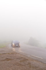 Fototapeta na wymiar The car on the road in dense fog.