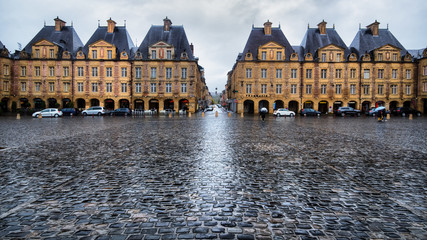 Warm yellow place Ducale buildings under rain in Charleville-Mezieres, France - 182758859