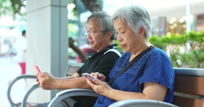 Asian senior couple use of cellphone together