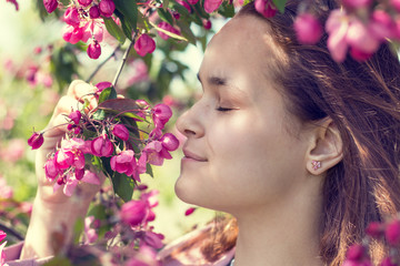Naklejka premium Young girl in an apple orchard in the springtime
