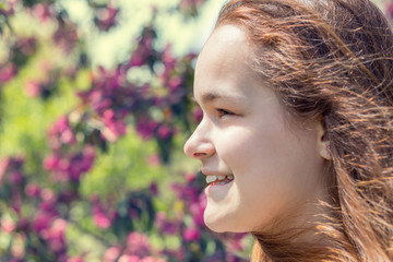 Naklejka premium Young girl in an apple orchard in the springtime