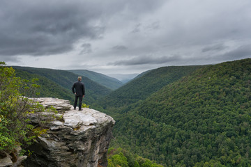Hiker reaching the edge of a cliff at Lindy Point Overlook in West Virginia 