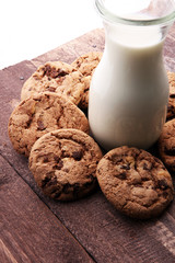 Chocolate chip cookies with milk on rustic wooden table