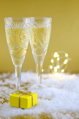 New Year's composition: Two glasses with champagne on a gold background.